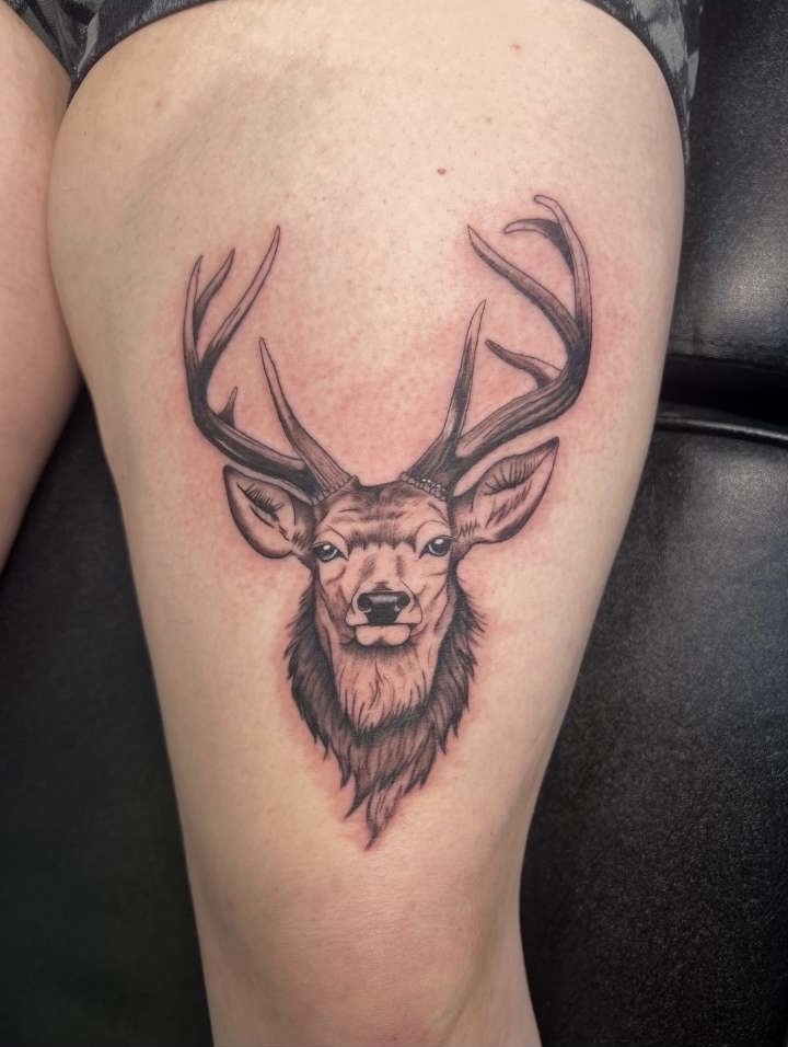 Black and grey realistic stag head with full antlers thigh tattoo