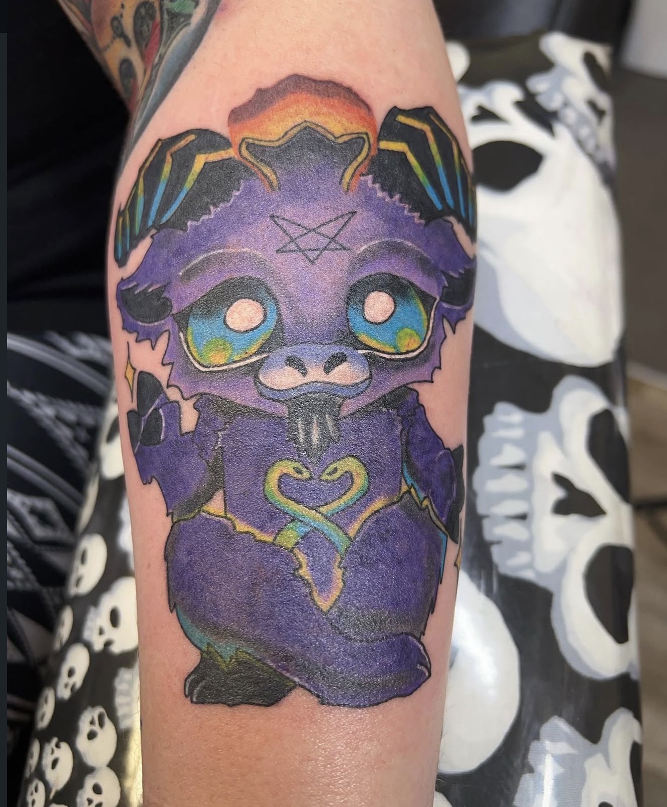 Full color purple baby dragon with rainbow wings arm tattoo