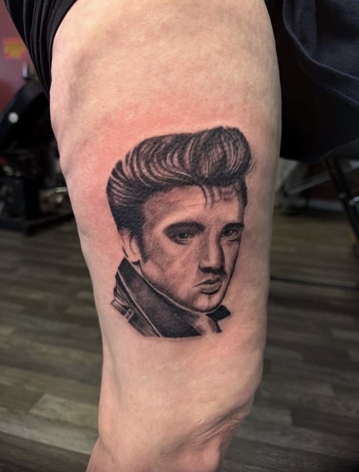 Black and grey Elvis Presley portrait thigh tattoo