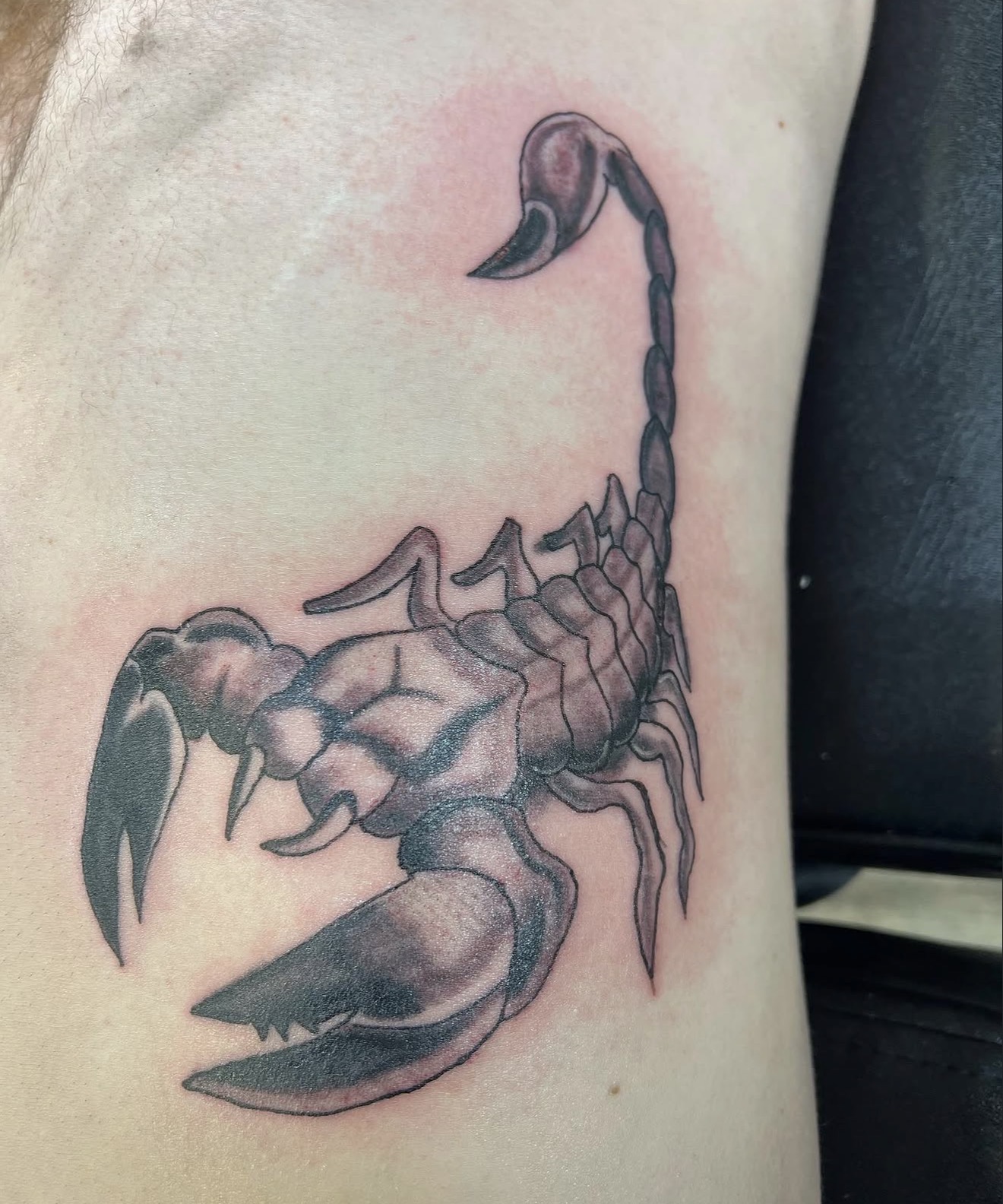 Black and grey realistic scorpion rib tattoo