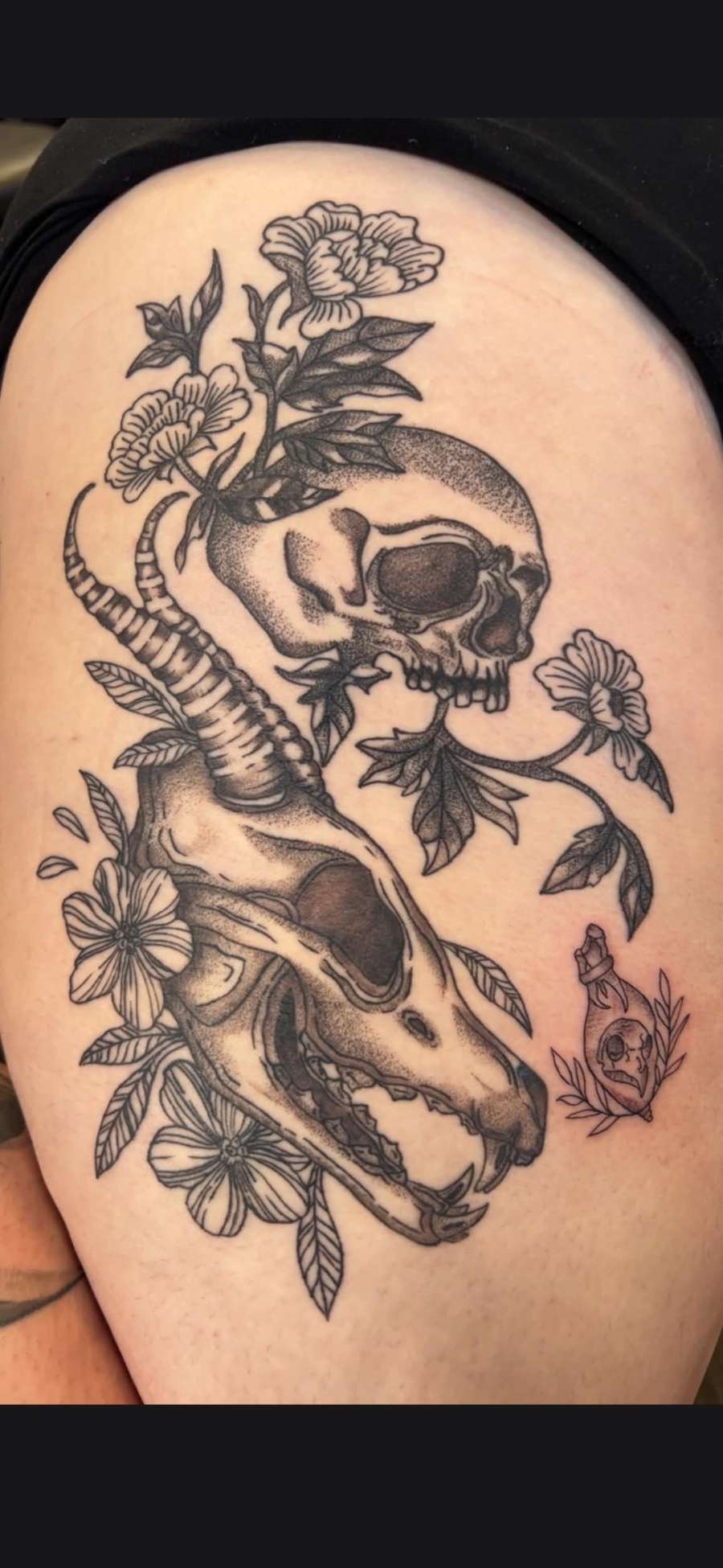 Black and grey dotwork animal skulls with florals thigh tattoo